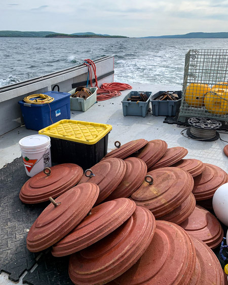 Red anchors and yellow mooring equipment near the back of a ship on a lake.