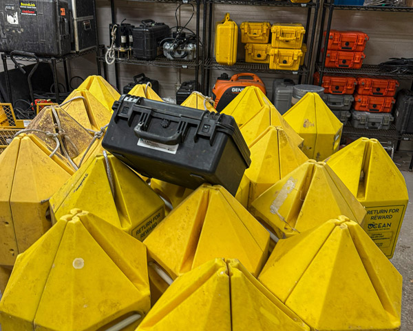Many yellow subsurface floats clustered together in a workshop.